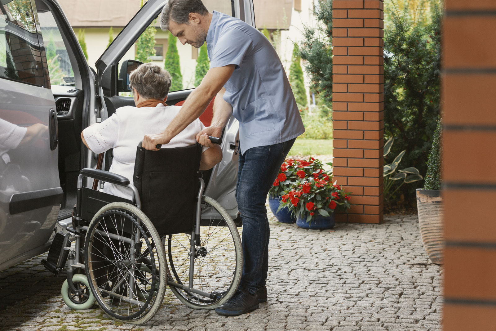 Caregiver helping a senior with hospital to home transportation